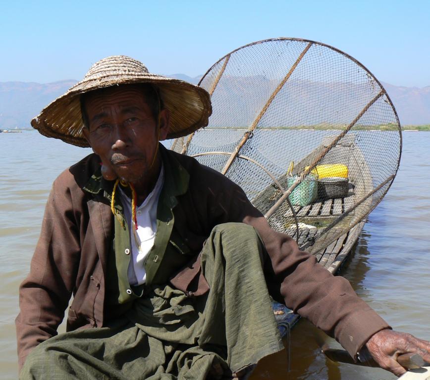 Silhouette of traditional fishermen throwing net fishing inle lake