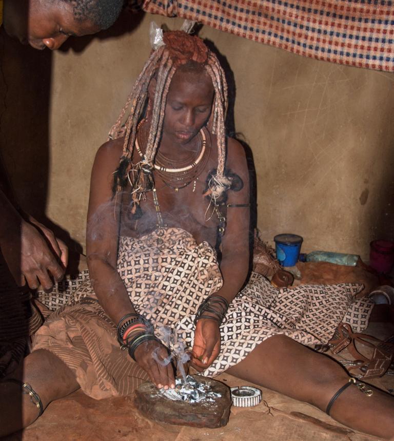 Himba woman preparing a smoke shower
