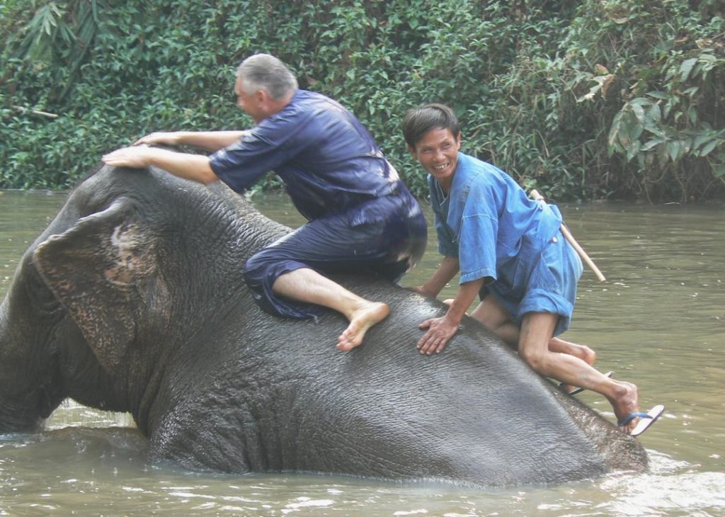 Its not easy to stay on the back of an elephant during bathing