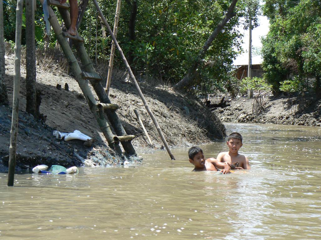 Boys catching horseshoe crabs at a canal leading to Don Hoi Lod, Thailand