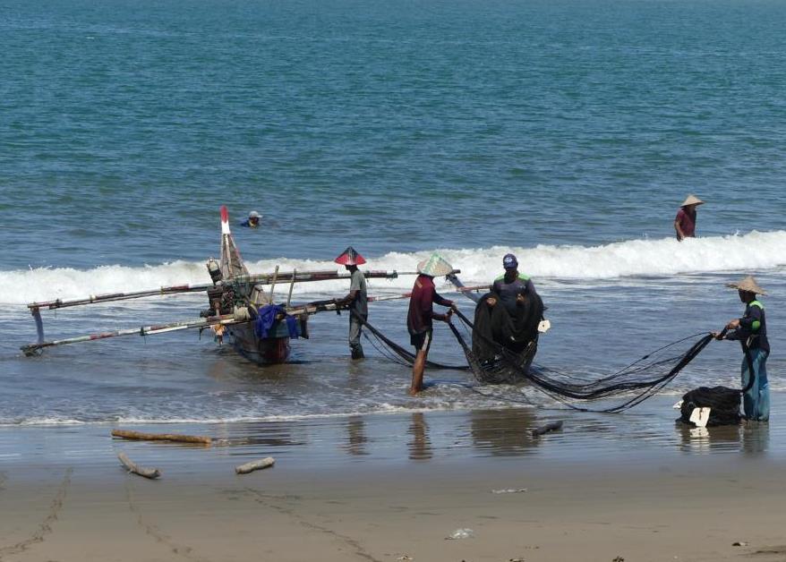 Fishermen hauling in seine net from Padang Beach