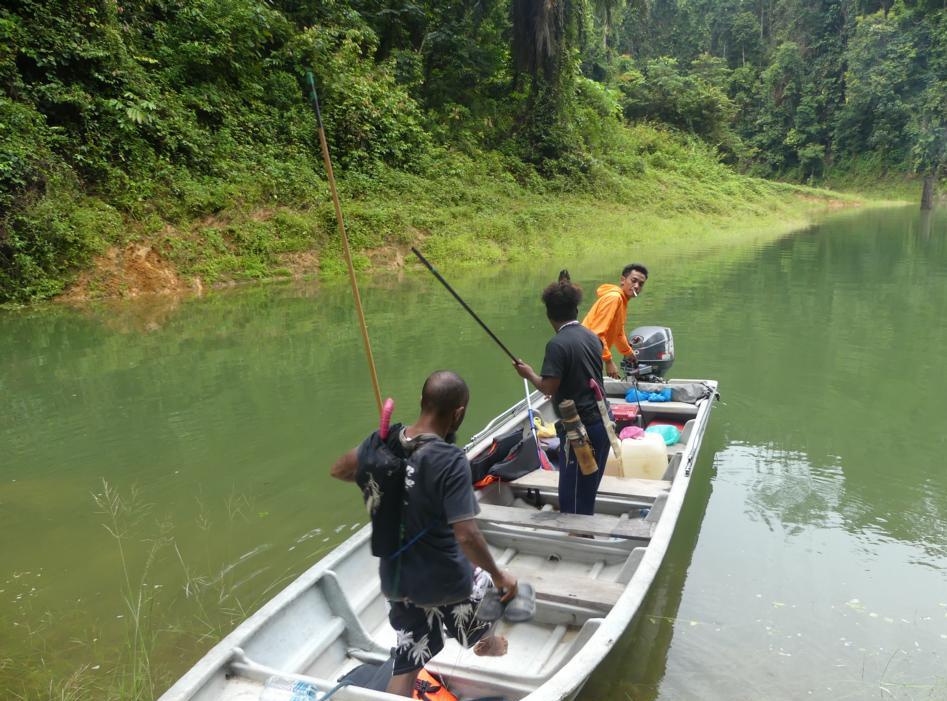 Orang Asli people landing with a boat to go blowpipe hunting
