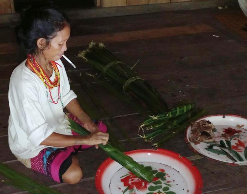 Mentawai preparing meat packets for relatives