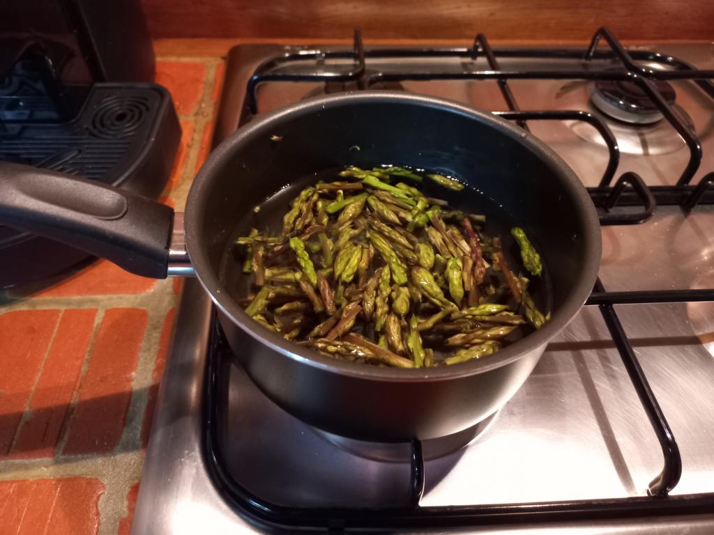 salting the boiling water of the wild asparagus tips
