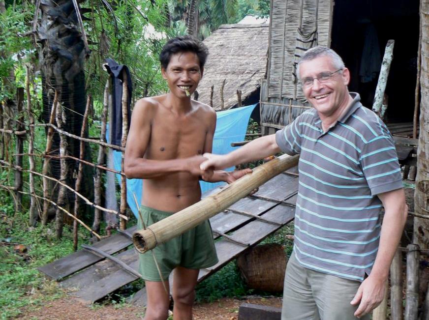Kurt Hoelzl receives an eel tube from a Cambodian fisherman