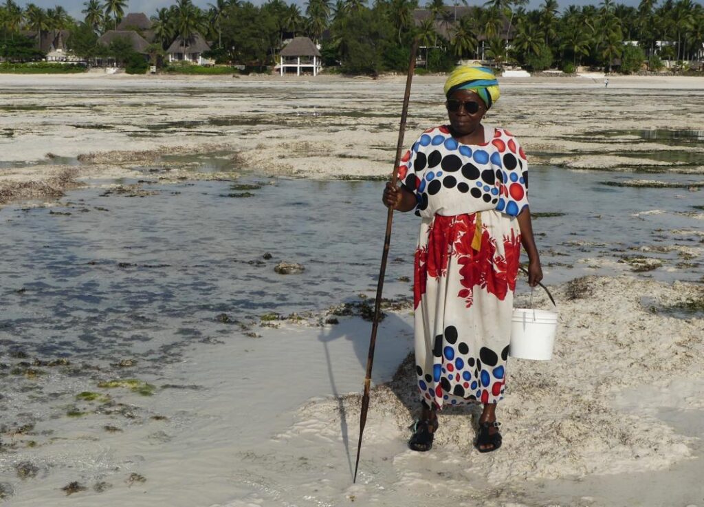 Beachcombing lady in Zanzibar with a spear