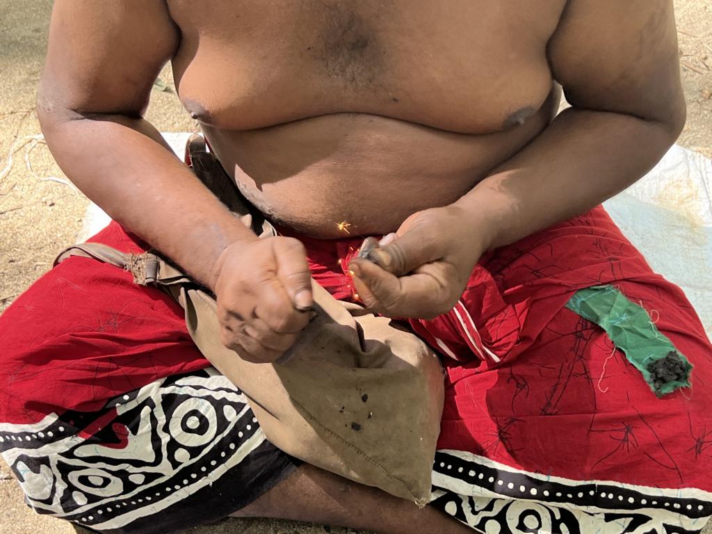 Vedda chipping the flintwith a steel to create a spark