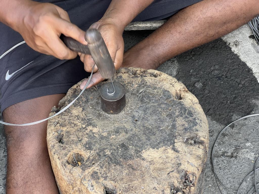 Hammering a fishing hook into shape
